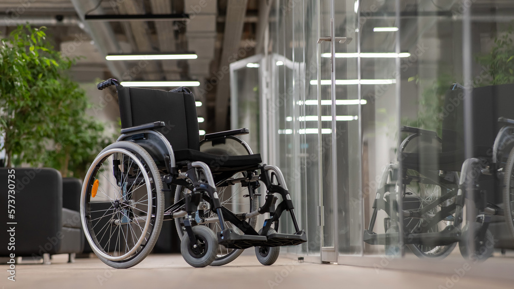 Empty wheelchair in the hallway in the office. Empty wheelchair in the hallway in the office.