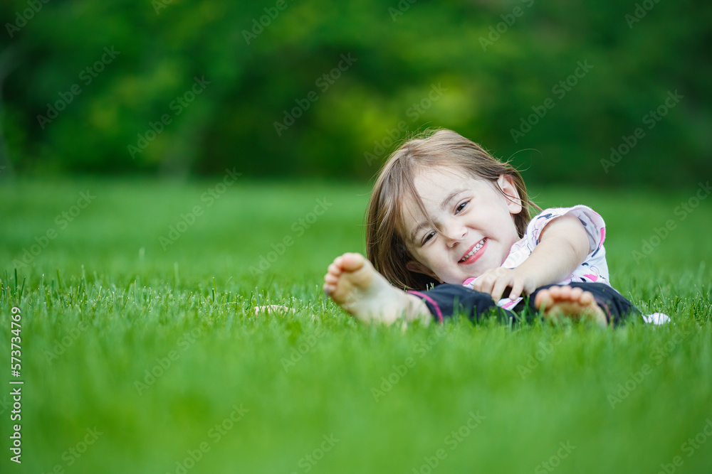 Happy child laying in perfectly manicured organic chemical-free green lawn grass Happy child laying in perfectly manicured organic chemical-free green lawn grass