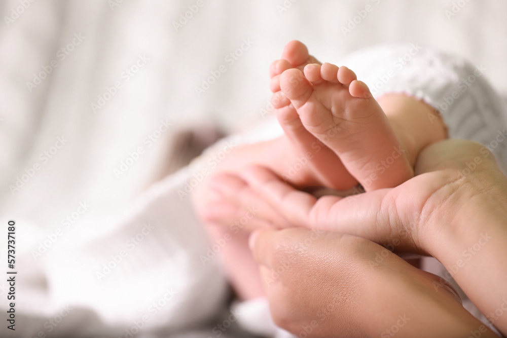 Mother and her newborn baby on bed, closeup. Space for text Mother and her newborn baby on bed, closeup. Space for text