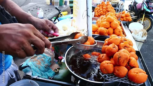 Filipino Street Food Called Kwek Kwek or fried chicken, duck or quail egg in orange colored batter. photo