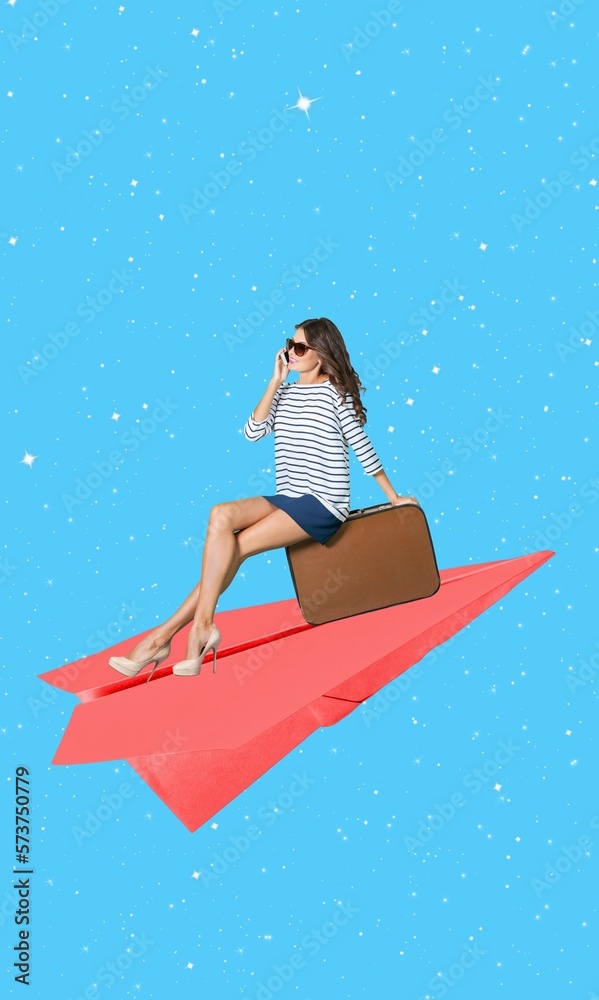 Happy young woman with suitcase on the paper plane