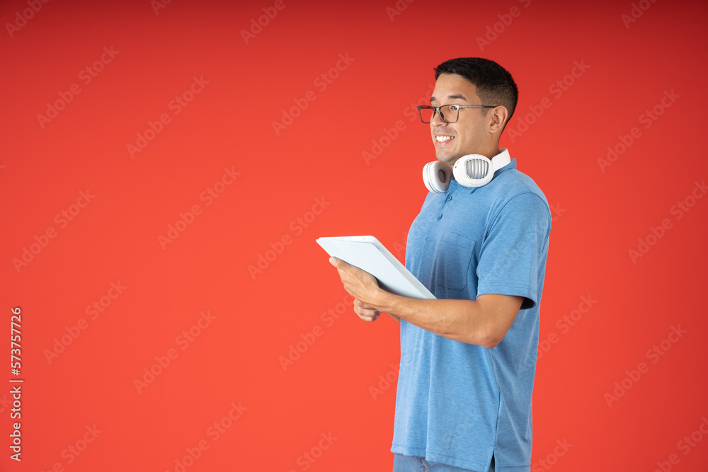 Young man with glasses, posing with a digital tablet and headphones Young man with glasses, posing with a digital tablet and headphones