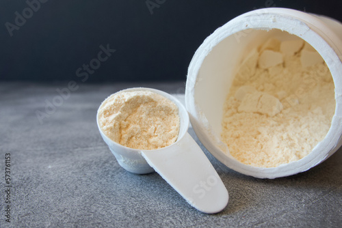 Open container with colostrum powder with measuring scoop