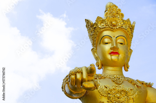 The golden god in Myanmar style is pointing at you.