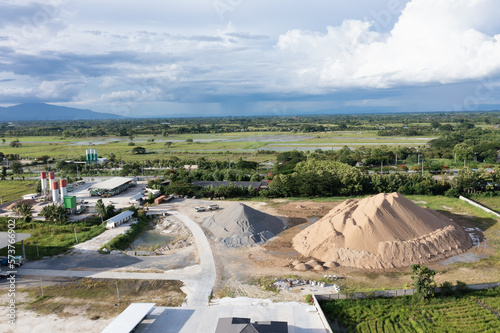 Pile of sand and rock or gravel in concrete plant with sky background in aerial view. Heap of aggregate or material from nature, mine or quarry for mix with cement, concrete for industry construction. © DifferR