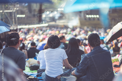 Photography Couple sitting in park watching concert at open air music festival