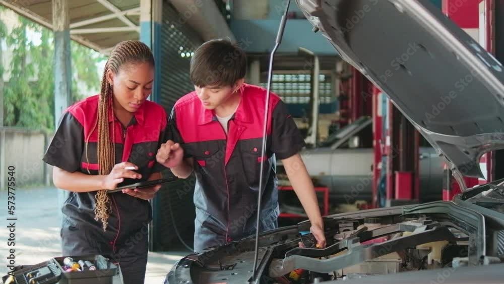 Two professional automotive mechanical partners check and repair an EV car battery and hybrid engine at a maintenance garage, expert electric vehicle service, and fixing occupations auto industry. Two professional automotive mechanical partners check and repair an EV car battery and hybrid engine at a maintenance garage, expert electric vehicle service, and fixing occupations auto industry.