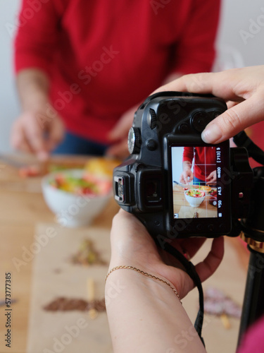 Photography studio shooting cooking blog content. Photo camera on tripod shooting how man is cooking