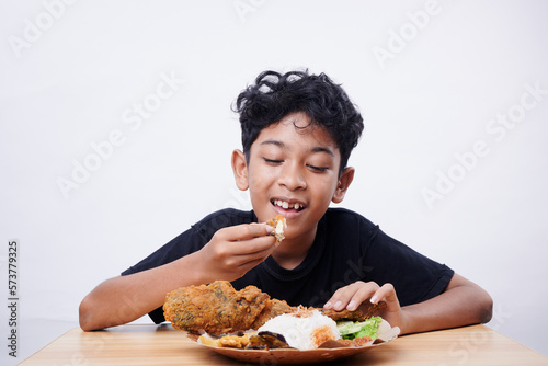 Little Boy eating Fried Fish and rice at home