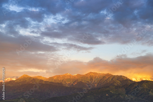 Almaty mountains illuminated by the rays of the setting sun at sunset.