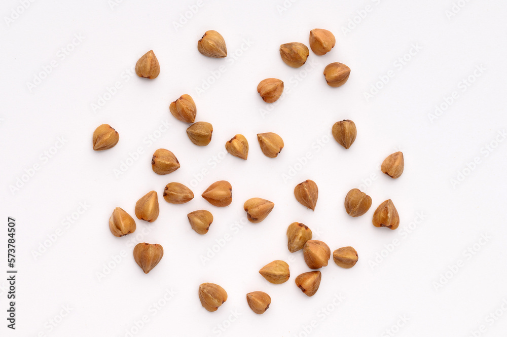Close-up, macro of buckwheat on a white background.Hypoallergenic pillow filling. Prevention of anemia. Close-up, macro of buckwheat on a white background.Hypoallergenic pillow filling. Prevention of anemia.