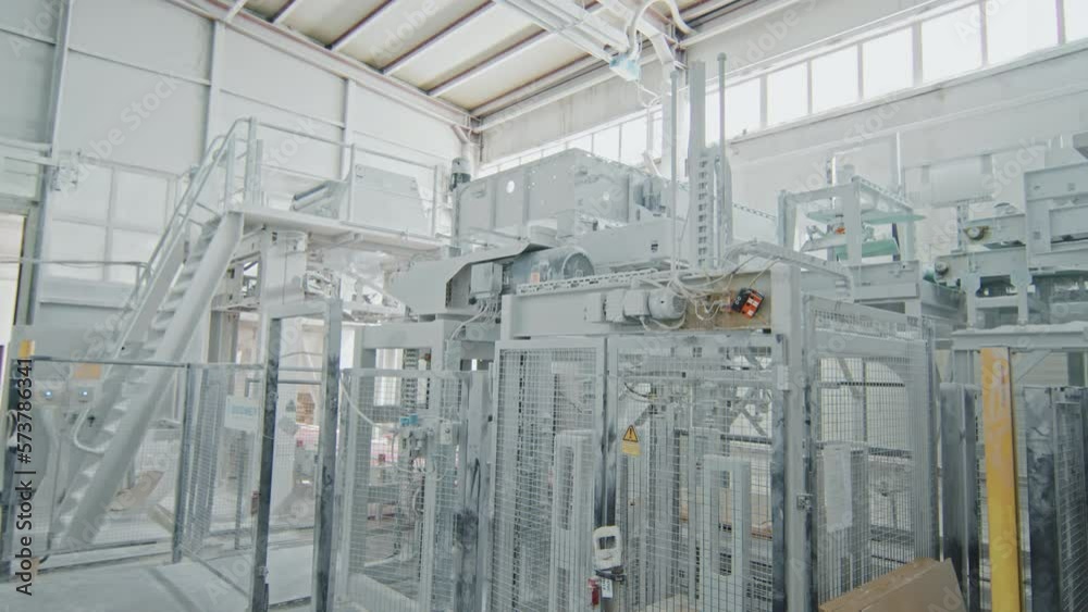 No people wide shot of white marble factory interior with modern industrial machines and equipment