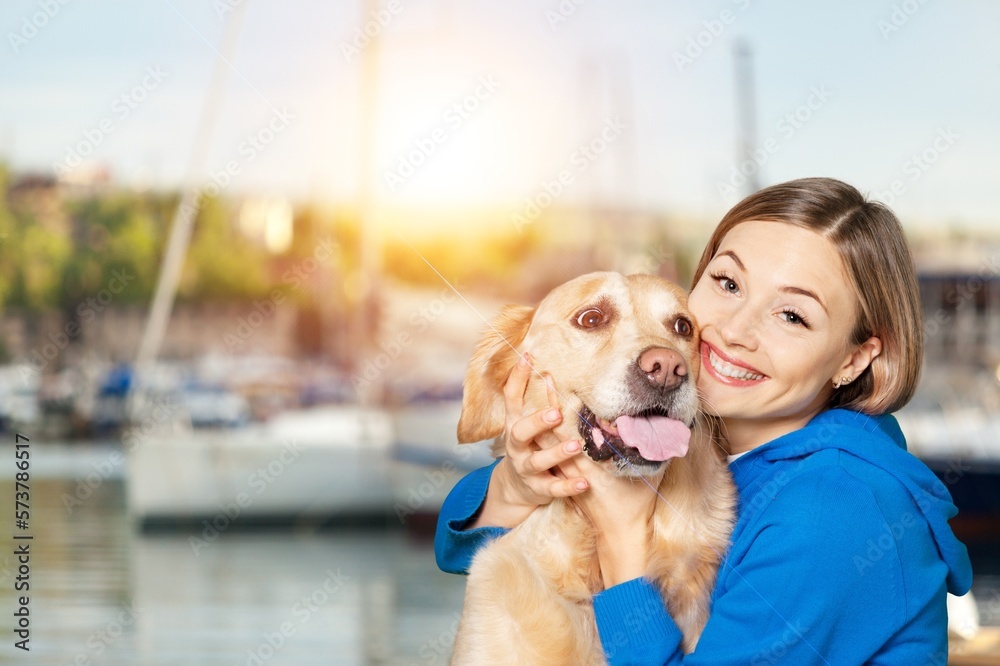 Young happy woman hugging cute domestic dog
