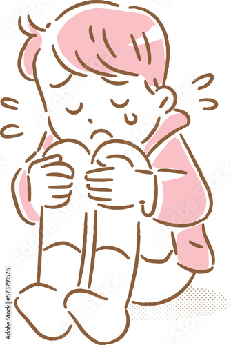 涙を流しながら膝を抱えてなく男の子