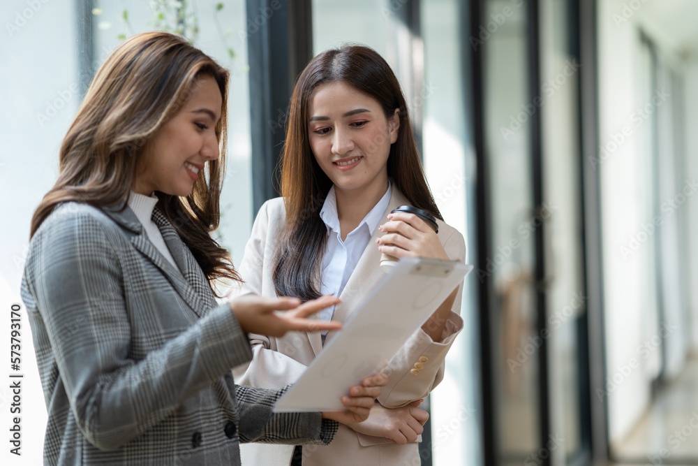 Obraz premium Beautiful confident asian businesswoman standing holding data graph. chart showing financial business growth. Consultation for marketing plans and customer groups.
