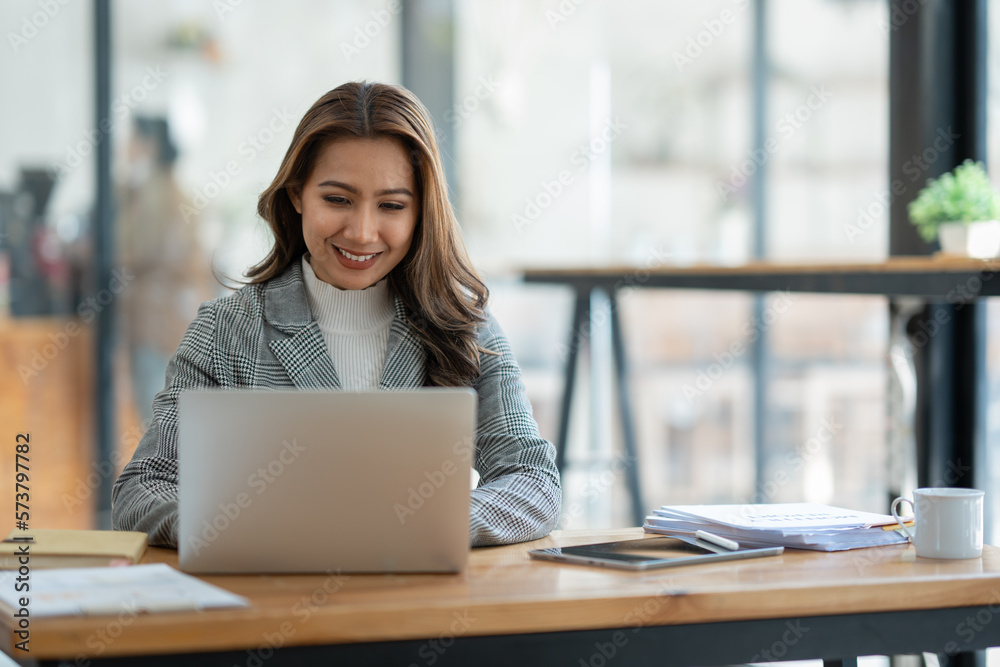 Attractive asian businesswoman sitting working with laptop computer on desk in business growth finance concept Happy marketing plan and customer segments in the office. Attractive asian businesswoman sitting working with laptop computer on desk in business growth finance concept Happy marketing plan and customer segments in the office.