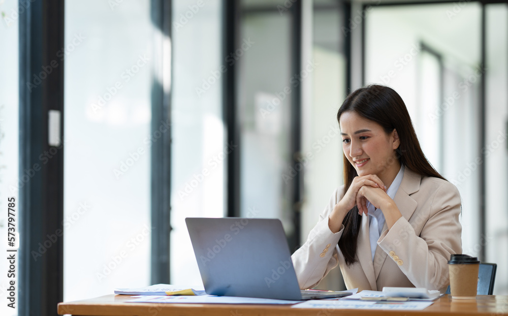Attractive asian businesswoman sitting working with laptop computer on desk in business growth finance concept Happy marketing plan and customer segments in the office. Attractive asian businesswoman sitting working with laptop computer on desk in business growth finance concept Happy marketing plan and customer segments in the office.