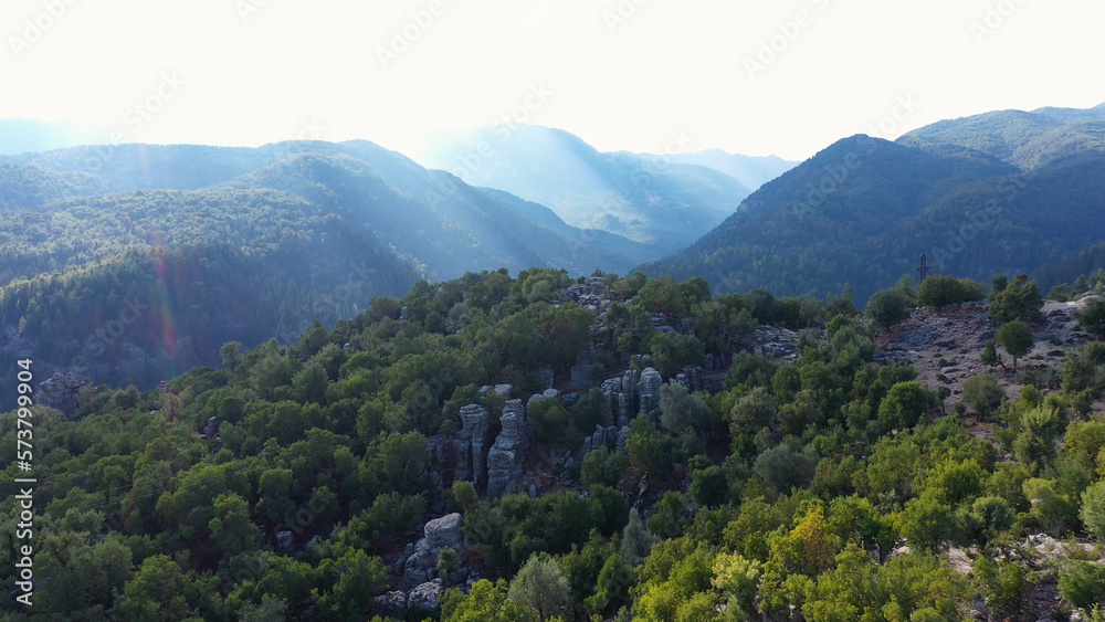 Aerial panoramic view of forested mountains slopes with rock formations. Spectacular nature background.
