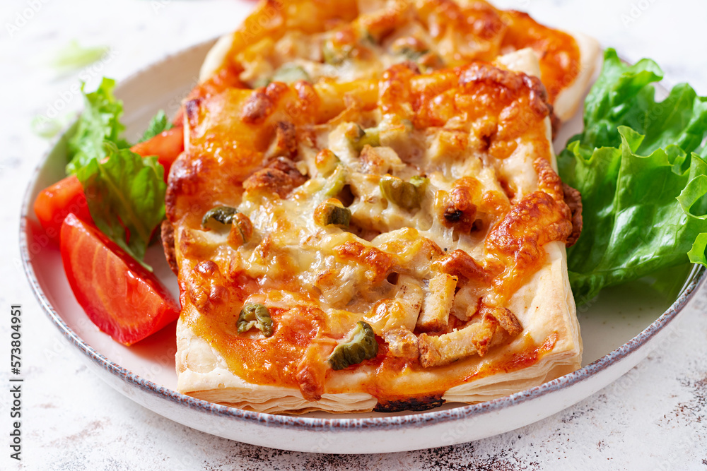 Children mini pizza , small open pies with ham, tomato sauce, mozzarella and cheese in basket on a light background. Children mini pizza , small open pies with ham, tomato sauce, mozzarella and cheese in basket on a light background.