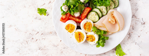 Ketogenic diet. Boiled eggs, ham, mozzarella cheese and fresh salad. Keto breakfast. Brunch. Top view, banner