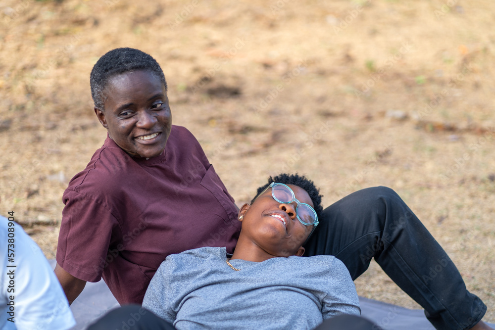 Fototapeta premium Two queer masculine women talking at the park 
