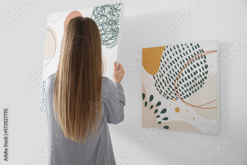 Woman hanging abstract canv...