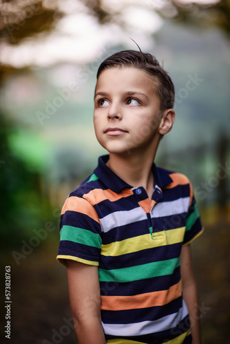 child standing outside and posing, a portrait of a boy