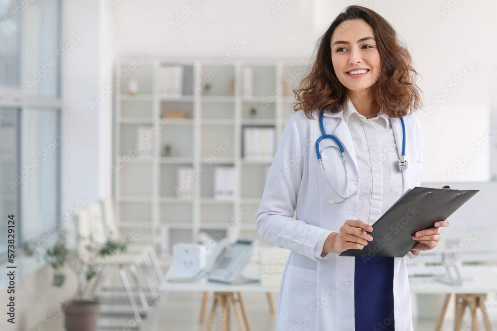 Young female doctor with clipboard in clinic Young female doctor with clipboard in clinic