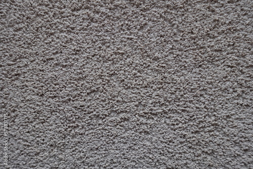 Close shot of dusty wall with coarse light gray roughcast finish photo