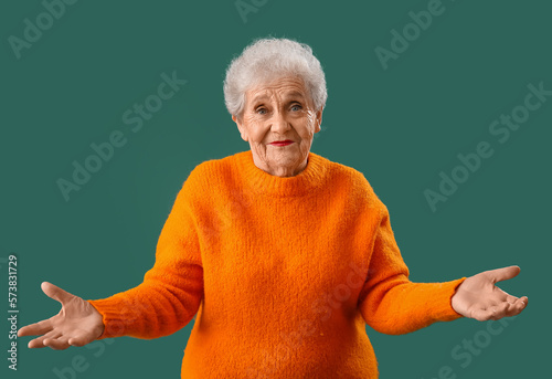 Senior woman in orange swea...