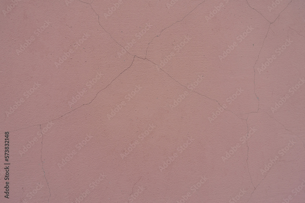 Close shot of dusty pastel pink painted wall with cracks