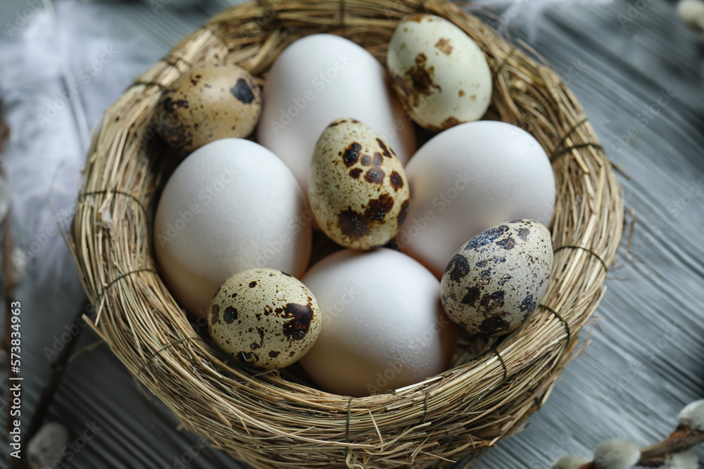 Nest of Easter eggs on grey wooden table, closeup Nest of Easter eggs on grey wooden table, closeup