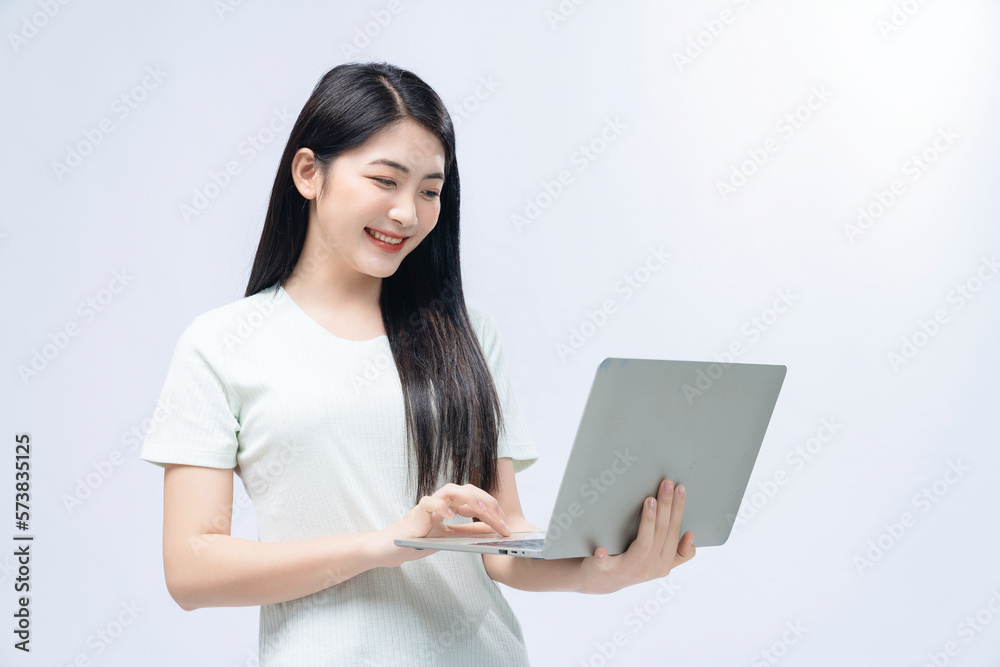 Young Asian girl holding laptop on background Young Asian girl holding laptop on background