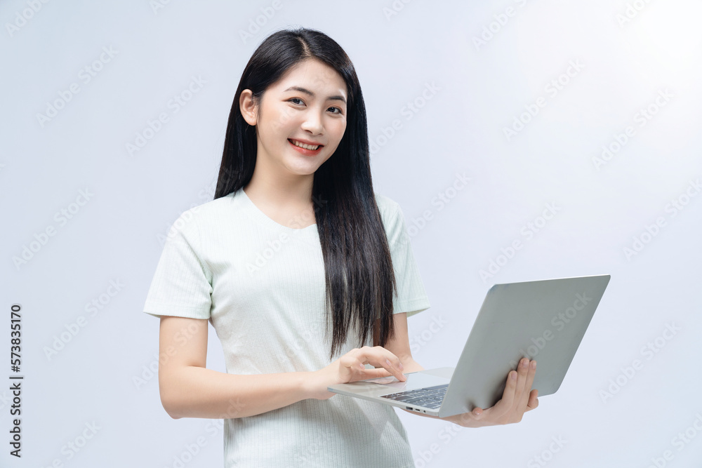 Young Asian girl holding laptop on background Young Asian girl holding laptop on background