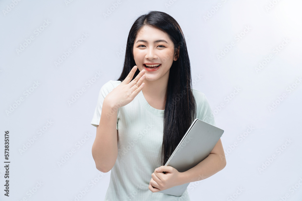 Young Asian girl holding laptop on background Young Asian girl holding laptop on background