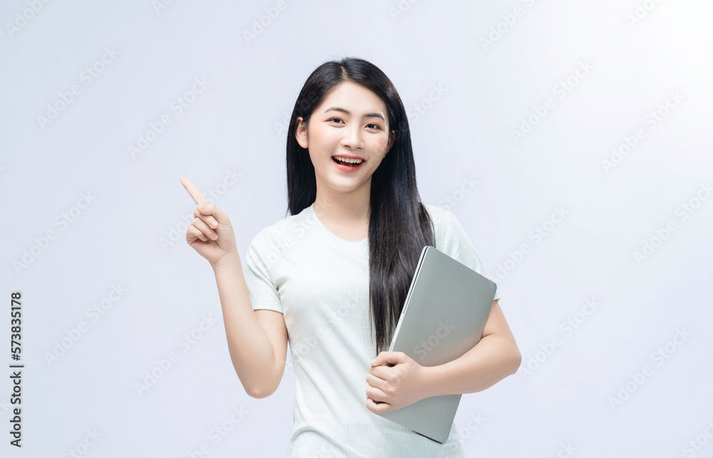 Young Asian girl holding laptop on background Young Asian girl holding laptop on background