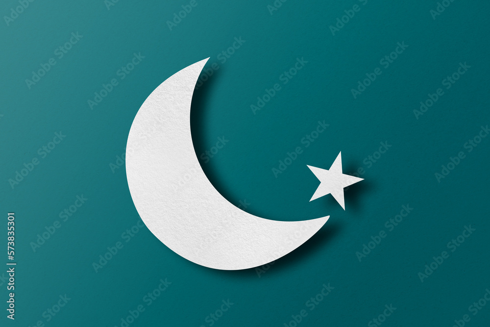 White paper cut into crescent shapes and stars set on green paper background. White paper cut into crescent shapes and stars set on green paper background.