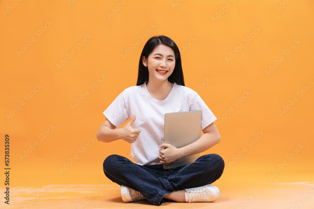 Young Asian girl using laptop on back ground Young Asian girl using laptop on back ground