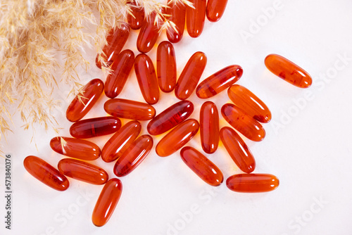 Vitamins for the heart, for children, taylets are scattered on the table. Red food additive, capsule, a heart form. A healthy lifestyle, prevention of diseases. High quality photo