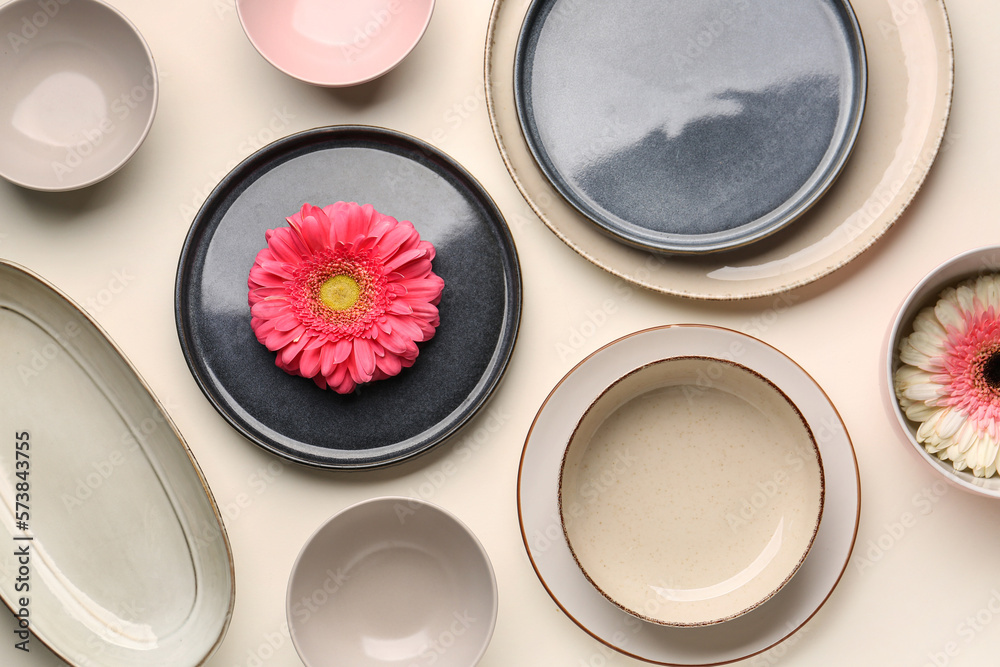 Composition with set of plates and chrysanthemum flowers on white background Composition with set of plates and chrysanthemum flowers on white background