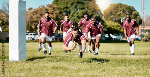 Rugby, team on field and sports game with men, athlete running and player score a try with ball, fitness and active outdoor. Exercise, championship match and teamwork with jump, action and energy © Anela R/peopleimages.com