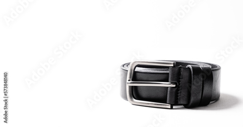 Black leather belt for trousers and jeans. Fastened fashionable men leather belt with dark chrome matted metal buckle isolated on white background. Male accessory. Luxury strap. Haberdashery goods