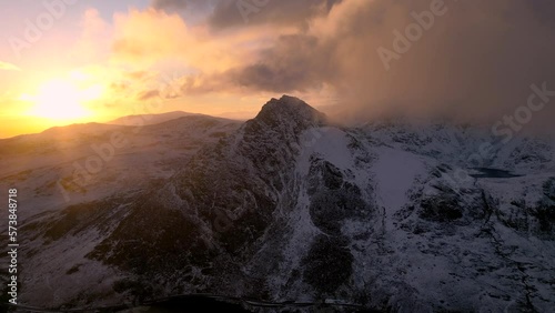 Aerial sunrise view of Tryfan in Snowdonia with low clouds and snow during winter