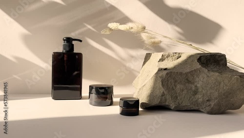 Product skin care cosmetic spa cream serum in the amber packaging.Beige background in the morning rays of the sun with a beautiful shadow of the leaves