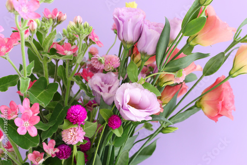 Top view image of pink and purple flowers composition over pastel background