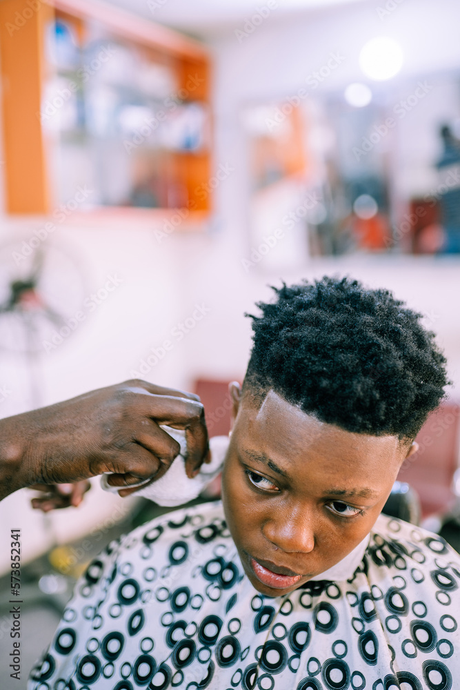 A young queer masculine woman getting a haircut A young queer masculine woman getting a haircut