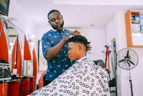 Obraz na płótnie A young queer masculine woman getting a haircut
