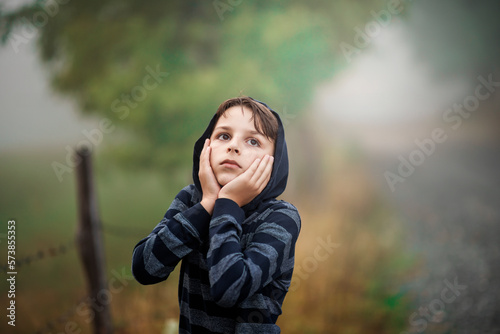 portrait of a sad boy outside in nature