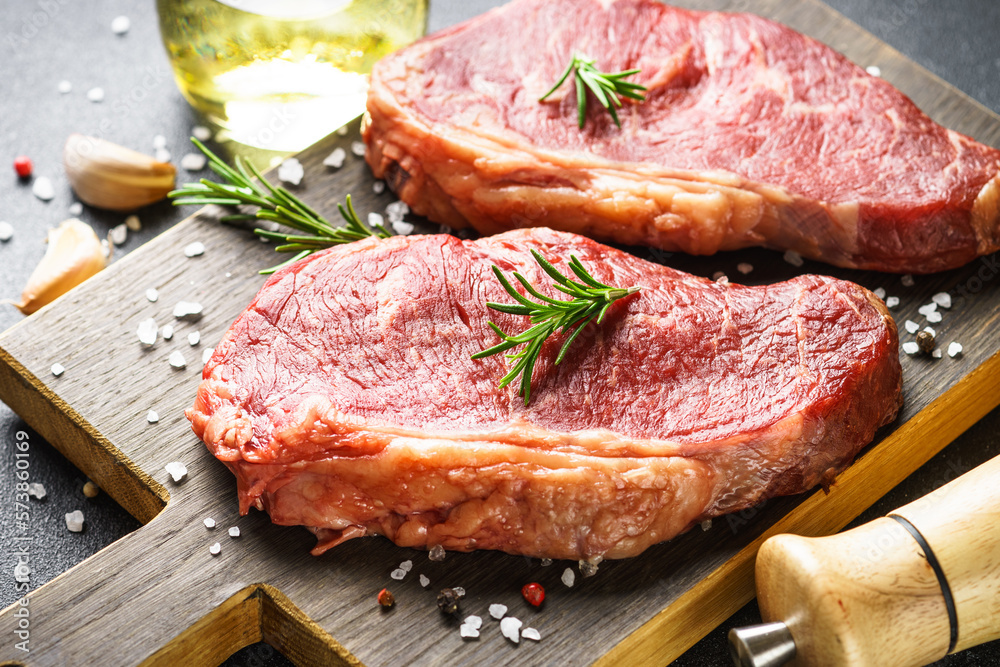 Beef steak with spices. Raw beef meat at cutting board. Close up. Beef steak with spices. Raw beef meat at cutting board. Close up.
