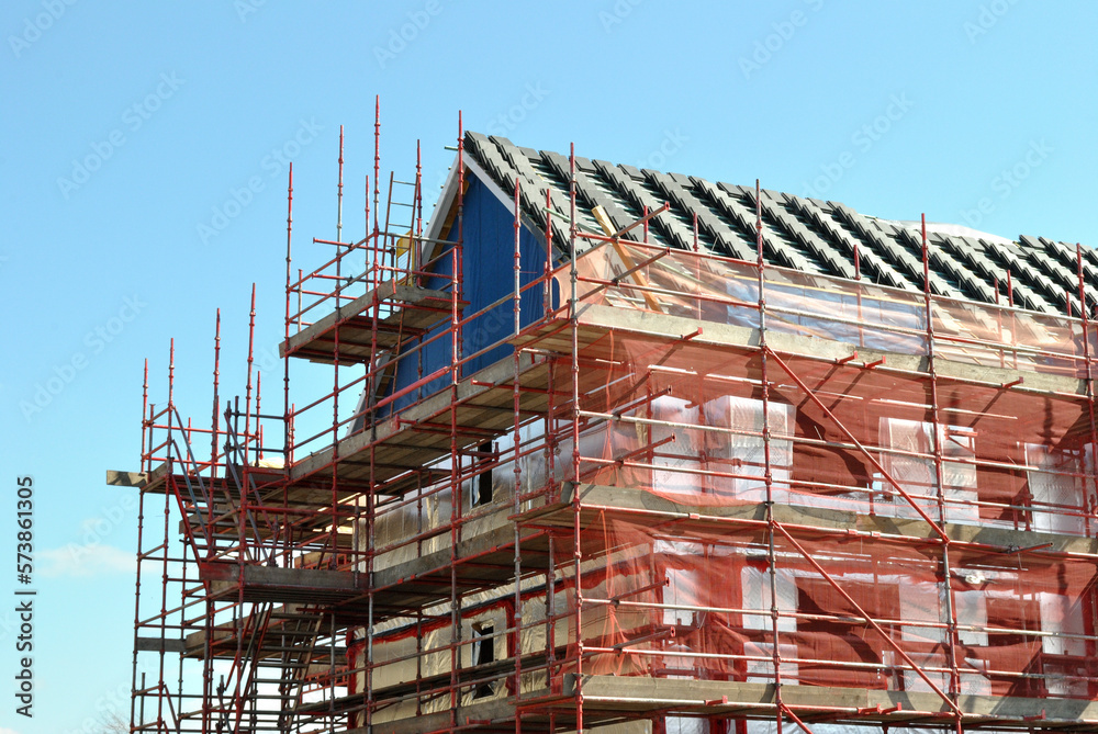 Building Under Construction with Metal Scaffolding on Summer Day with Blue Sky